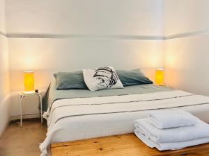 a bedroom with a large bed with two lamps at Los Olivos Apart in Cafayate