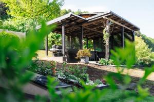 a wooden pergola in the middle of a garden at Boutique Apartments Daniela in Faak am See