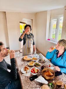 a group of people sitting around a table eating food at wine valley in Udabno