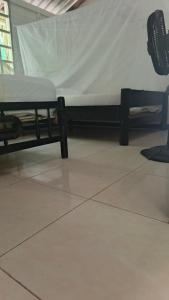 a room with two beds and a chair in it at Coco Encantado Eco Hostal Camping in Cartagena de Indias