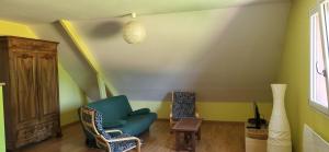 a living room with a blue chair and a table at proche d'Yvetot in Valliquerville