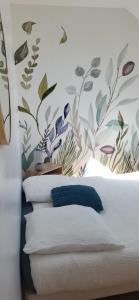 a bedroom with a bed with a floral wallpaper at proche d'Yvetot in Valliquerville
