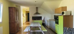 a kitchen with a table in the middle of it at proche d'Yvetot in Valliquerville