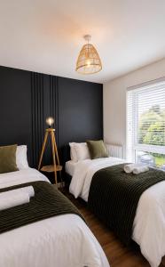 a bedroom with two beds and a chandelier at LushMint&Sound in Bristol