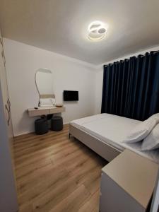 a small bedroom with a bed and a tv at Blue32 in Sarandë