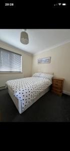 a bedroom with a large bed and a wooden dresser at Saddlebrook 156 in Leysdown-on-Sea