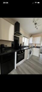 a kitchen with white cabinets and a black counter top at Saddlebrook 156 in Leysdown-on-Sea +3 photos