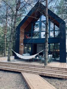 a hammock in front of a house with trees at Moje sPokoje in Morgowniki
