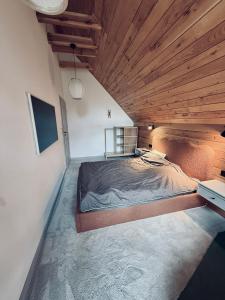a bedroom with a large bed with a wooden ceiling at Moje sPokoje in Morgowniki