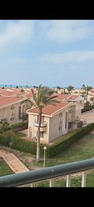 a house with a palm tree in front of it at Diamond Beach In Marina, Egyptw in Dawwār Abū Maḩrūs