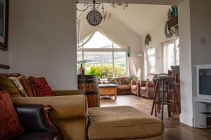 a living room with a couch and a clock on the wall at Bella Vista in Carlingford
