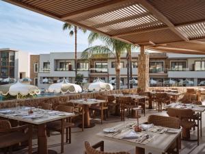 an outdoor restaurant with tables and chairs and palm trees at Lesante Classic - Preferred Hotels & Resorts in Tsilivi