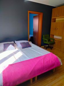 a bedroom with a large bed with a pink blanket at Siedlisko Grzegorza in Leśniki