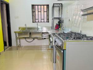 a kitchen with a sink and a stove in it at Abi's Place Benin in Benin City