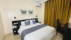 a bedroom with a large bed with a desk and a bed sidx sidx sidx at Abi's Place Benin in Benin City +33 photos