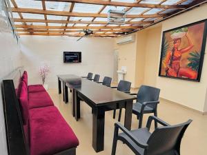 a conference room with a table and chairs and a painting at Abi's Place Benin in Benin City