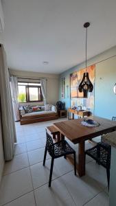 a living room with a table and chairs and a couch at Apartamento - Garden Flat Mar Azul in Taíba