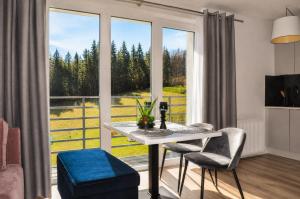 a living room with a table and chairs and a large window at Willa Apart 19A in Karpacz