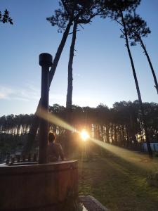 a person sitting on a bench watching the sunset at Complejo Turistico Chuy in Barra del Chuy
