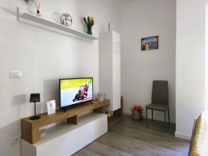 a living room with a tv and a chair at La Casina di Orsolina - Check-in Flessibile in Livorno