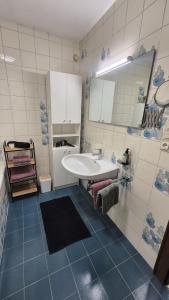 a bathroom with a white sink and blue tiles at Ferienwohnung Sonnweber in Stanzach +6 photos