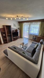 a living room with a large couch in the middle at Ferienwohnung Sonnweber in Stanzach