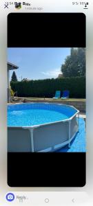a picture of a swimming pool with two blue chairs at Vila Pogled in Novi Sad
