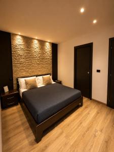 a bedroom with a bed and a brick wall at B&B La Bouganville in Alghero