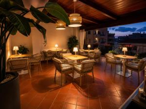 a restaurant with tables and chairs on a patio at B&B La Bouganville in Alghero