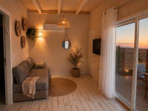 a living room with a couch and a large window at בריאה אירוח בטבע in Sha'al