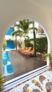 an archway in a building with a pool and benches at Casa boa vida in Jericoacoara
