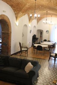 a living room with a couch and tables and chairs at Alojamiento El Monasterio in Almonaster la Real