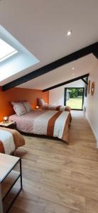 two beds in a bedroom with orange walls at Gîte des Tamaris Maison Chaleureuse proche Circuit in Arnage +38 photos