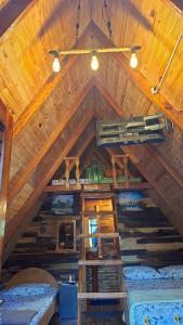 a attic room with two beds and a ceiling at Cabañas Gonga - Posada turistica in Ciudad del Este