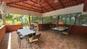 a patio with tables and chairs and a bar at La Esmeralda Villa in Orotina