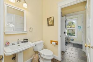 a bathroom with a toilet and a sink and a mirror at Bella Mar in Nehalem +43 photos