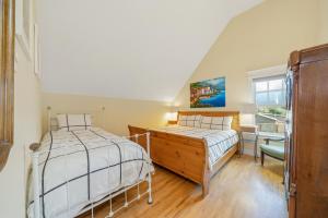 a bedroom with two beds and a desk and a window at Bella Mar in Nehalem