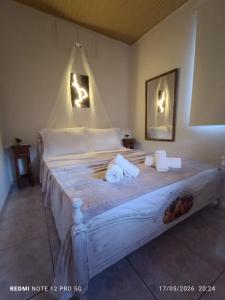 a bedroom with a white bed with towels on it at GIATRELOS HOUSE "near the shipwreck Zakynthos" in Volímai