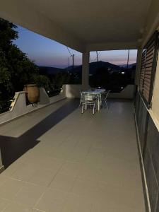 a patio with a table and chairs on a house at Bazakos Luxury Kampi Beach Studio 2 in Fournoi +5 photos
