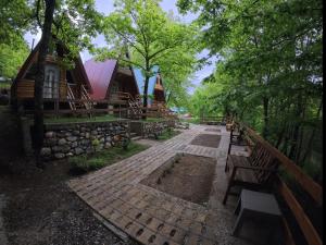 a path in front of a cabin with benches at Tri breze in Kolašin