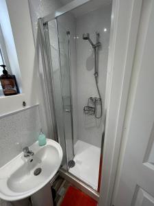 a white bathroom with a shower and a sink at Self-Contained Studio with Ensuite & Private Access in Hardwicke