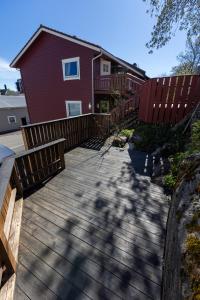 a wooden walkway in front of a red house at Storgata 49 Appartements Svolvær in Svolvær