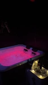 a pink pool of water sitting on top of a table at L'instant Désir love room jacuzzi in Ferrières