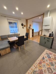 a kitchen and a living room with a table and chairs at Panzers Ferienwohnungen in Asparn an der Zaya