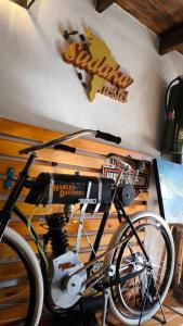 a bike parked next to a wall with a sign on it at Hostel y Motoposada Sudaka in Garupá +8 photos