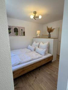 a bed with white sheets and pillows in a room at Ferienwohnung Thomas in Oberau