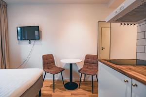 a room with two chairs and a table and a tv at Edsviken Hotell in Stockholm