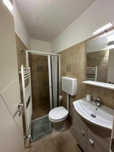 a bathroom with a toilet and a shower and a sink at Piazza San Giorgio B&B in Serrano +4 photos