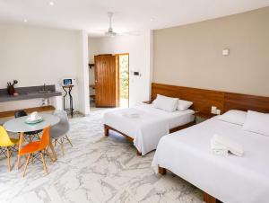 a hotel room with two beds and a table and chairs at Hotel Céntrico Tulum in Tulum +23 photos
