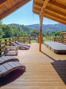 a wooden deck with benches and a view of the mountains at House Villa Ursus in Gerovo